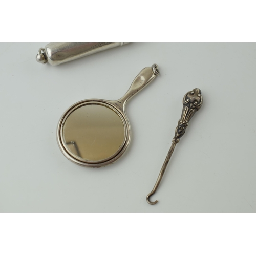 116 - Miniature silver mirror, Birmingham 1910, with a silver buttonhook and a silver tube box, Birmingham... 