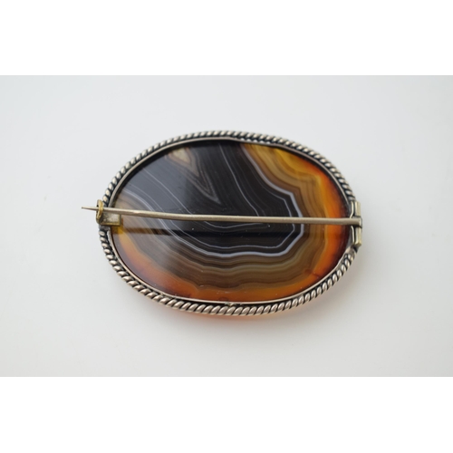 36 - Victorian silver agate brooch with silver rope border, 6cm diameter.