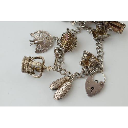 78 - Silver charm bracelet with charms to include a crown, a bear and others, 46g.