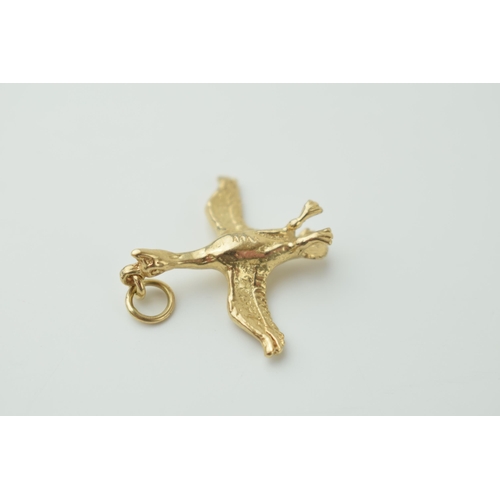 127 - 9ct gold charm / pendant in the form of a flying duck, 3.5 grams, 30mm long.