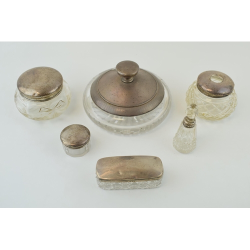 595 - A collection of silver and glass items to include a small scent bottle, a large compact with mirror,... 