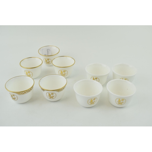 113 - De Lamerie Fine Bone China tea cups with gilt design and Qatar Coat of Arms, in three varying styles... 