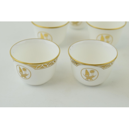 113 - De Lamerie Fine Bone China tea cups with gilt design and Qatar Coat of Arms, in three varying styles... 