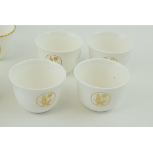 113 - De Lamerie Fine Bone China tea cups with gilt design and Qatar Coat of Arms, in three varying styles... 