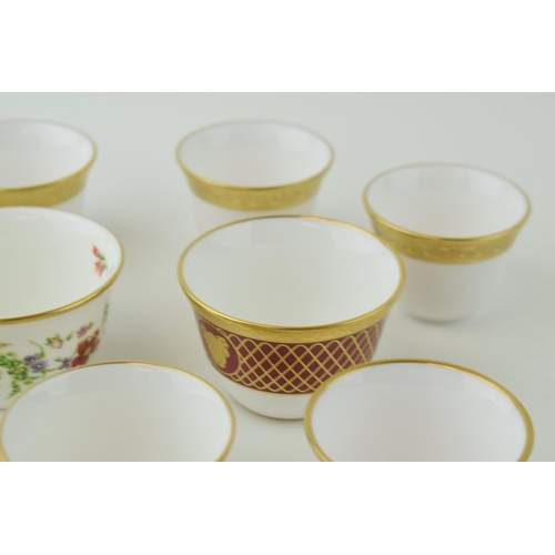 114 - De Lamerie Fine Bone China tea bowls and similar to include a red spiral and twist cup, a floral exa... 