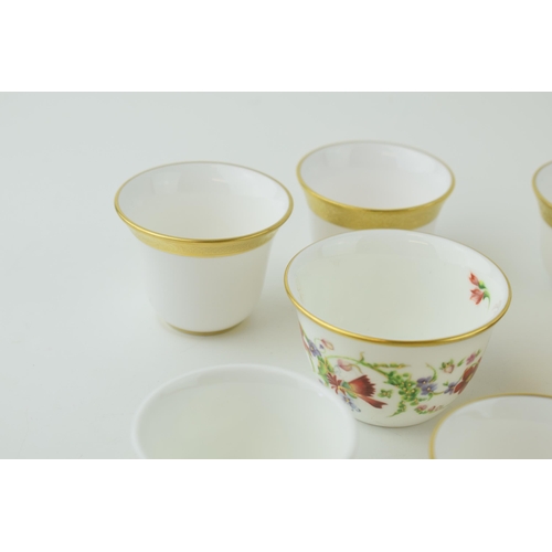 114 - De Lamerie Fine Bone China tea bowls and similar to include a red spiral and twist cup, a floral exa... 