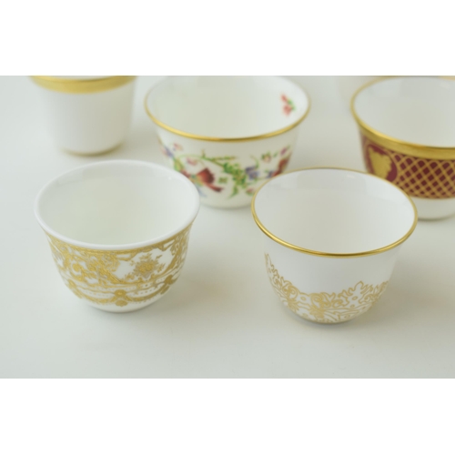 114 - De Lamerie Fine Bone China tea bowls and similar to include a red spiral and twist cup, a floral exa... 