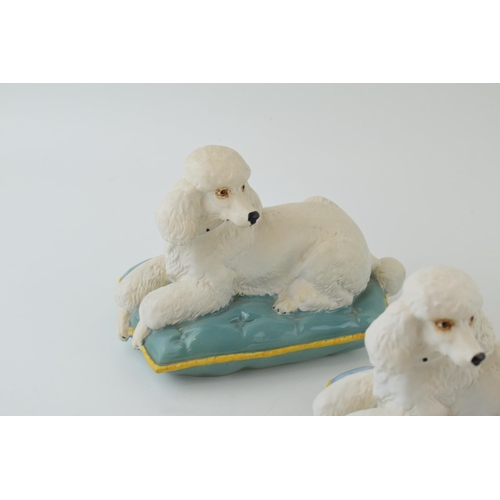 167 - A trio of Beswick models of a Poodle on Cushion 2985, 2 with a turquoise cushion and one on a lilac ... 