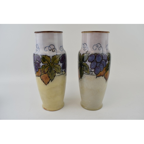 190 - A pair of Royal Doulton Lambeth vases with summer fruits decoration, 25cm tall (2).