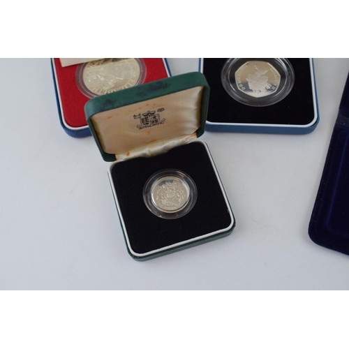 629 - Four cased sterling silver proof coins to include Piedfort Twenty Pence, a 50p, a pound coin and a c... 