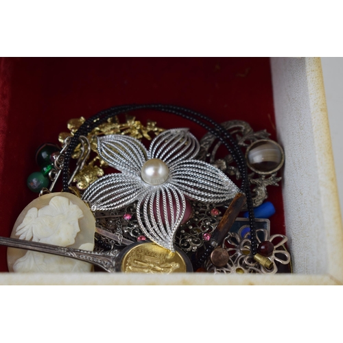 634 - A jewellery box containing a quantity of costume jewellery such as brooches, rings, necklaces and ot... 