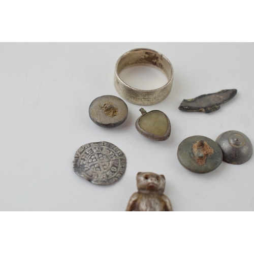 652 - A collection of metal detecting finds to include a silver teddy charm, a hammered silver coin, middl... 