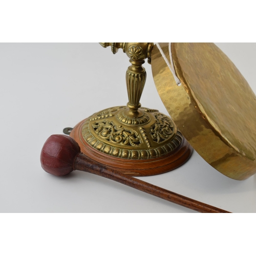 318 - Wall mounted brass dinner gong with leather ended striker, wooden mount, 21cm diameter of gong.