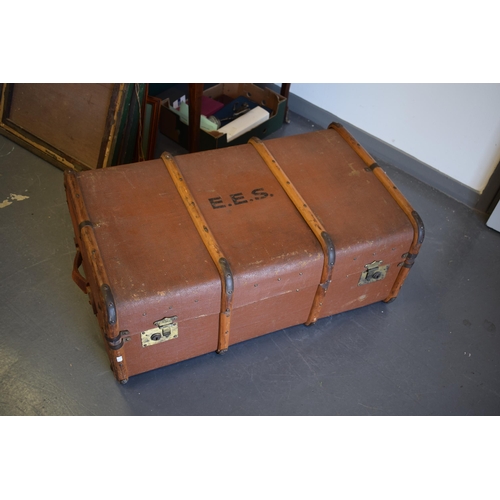 331 - A travel trunk with wooden banding and brass catches. Inner tray present and clean. Leather straps t... 