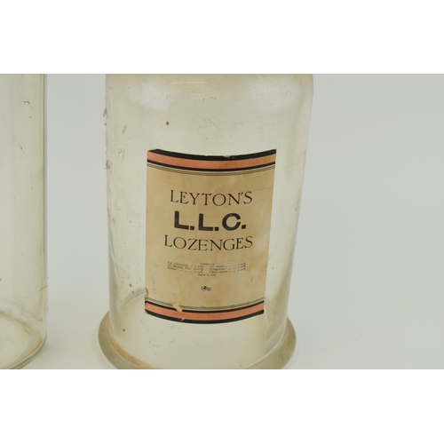 355 - A pair of large 20th century oversized glass chemist jars to include Leyton's LLC Lozenges and one s... 