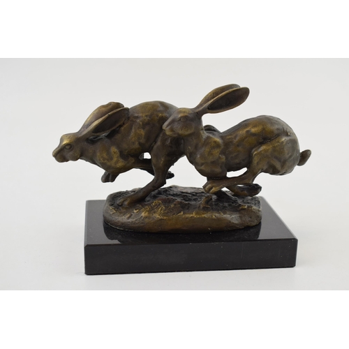 444 - Contemporary bronzed sculpture of a pair of running hares, mounted onto a marble base, indistinct si... 