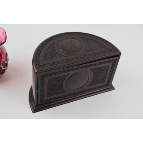 450 - A vintage Bakelite cigarette box , demi-lune form, 16cm wide, with a cranberry glass vase with overl... 