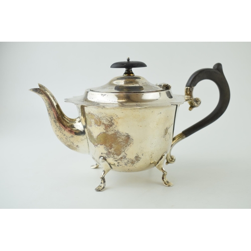 Hallmarked silver teapot with scroll-like handle, rasied on four feet, with ebony-style handles, Chester 1906, gross 313.2g.