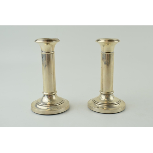 577 - A pair of loaded silver candlesticks, plain columns, 11.5cm tall (2), Birmingham 1947.