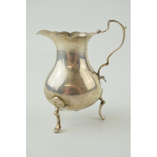 591 - Victorian silver cream jug, raised on three feet, London 1892, 11cm tall, 118.4g.