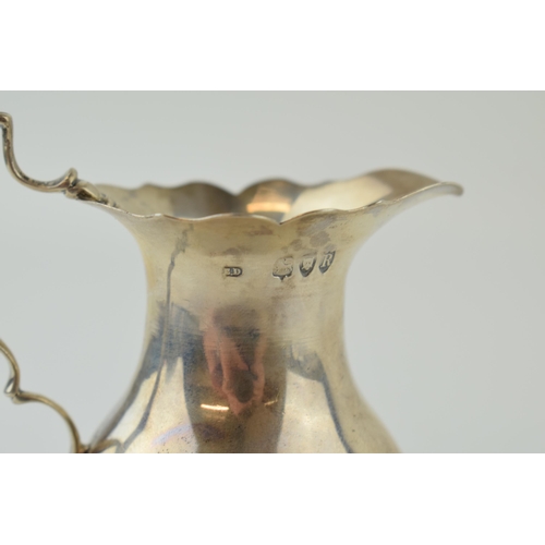 591 - Victorian silver cream jug, raised on three feet, London 1892, 11cm tall, 118.4g.