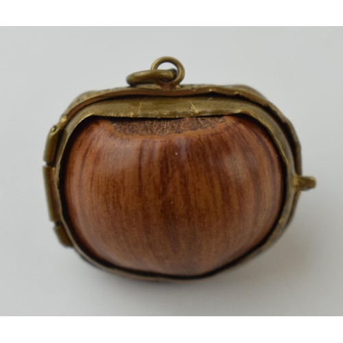 640 - A miniature purse made form a hazelnut shell with brass hinge and mount. 2.5cm.