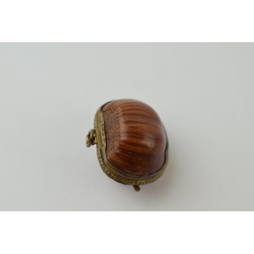 640 - A miniature purse made form a hazelnut shell with brass hinge and mount. 2.5cm.