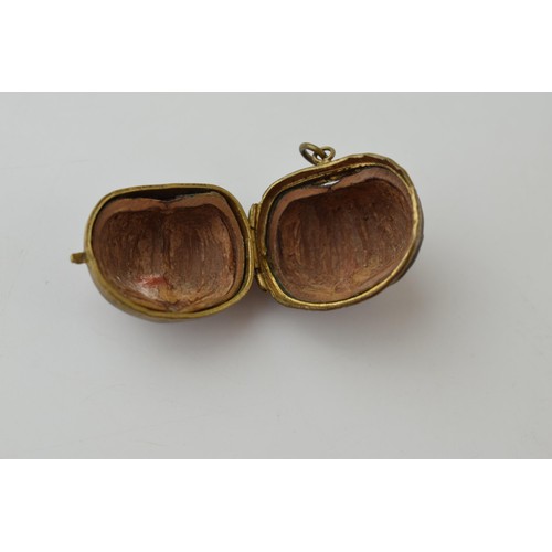 640 - A miniature purse made form a hazelnut shell with brass hinge and mount. 2.5cm.