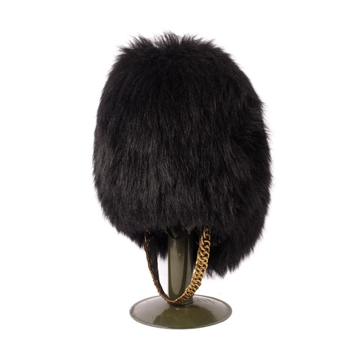 104 - Grenadier Guards Bearskin Headdress on Military Tin Hat Stand dated 1970 with Sam Browne Belt