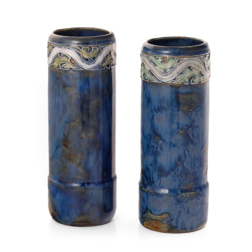 179 - A near pair of Royal Doulton stoneware cylindrical vases, with tubelined decoration to the tops, on ... 