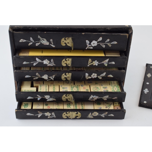 106 - A Mah-Jong set in original lacquered case with mother of pearl inlaid design. Four internal drawers ... 