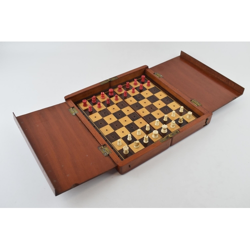 20 - Mahogany cased travel chess set with bone pieces. Case is hinged and folds for transportation.