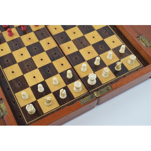 20 - Mahogany cased travel chess set with bone pieces. Case is hinged and folds for transportation.