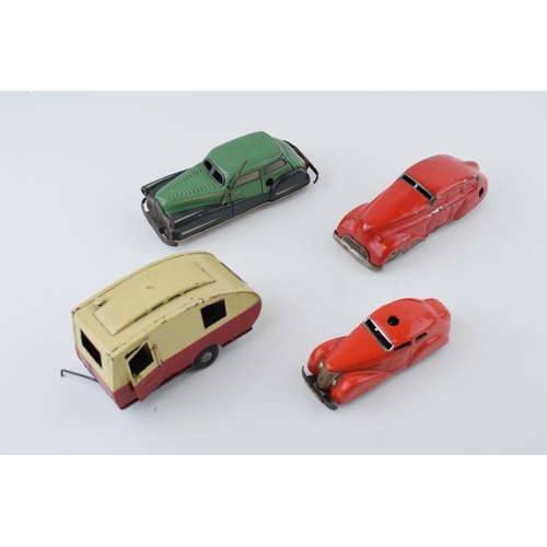 83 - A collection of tin toys and clockwork vehicles to include examples by Tri-ang Minic, Shuco and othe... 