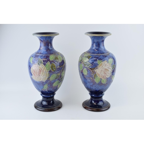 180 - A pair of Royal Doulton stoneware baluster vases with tubelined decoration of roses, on blue backgro... 