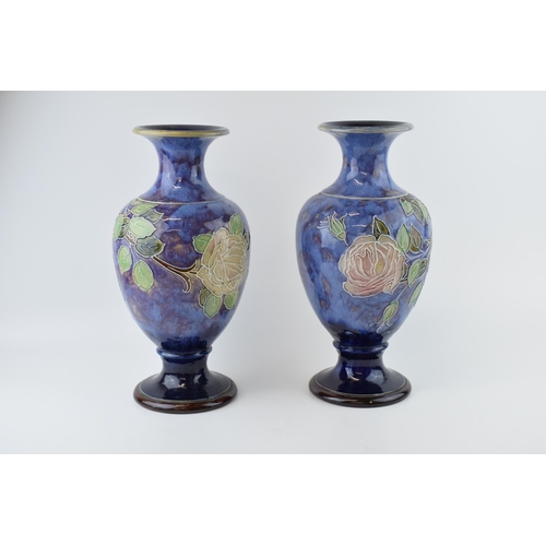 180 - A pair of Royal Doulton stoneware baluster vases with tubelined decoration of roses, on blue backgro... 