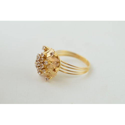 225 - Yellow metal (tests as 18ct or better) ring, floral head set with white stones, with textured leaf d... 