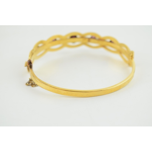 242 - Cased yellow metal (tests as 9ct gold or higher) bangle, set graduated Amethyst stones with safety c... 