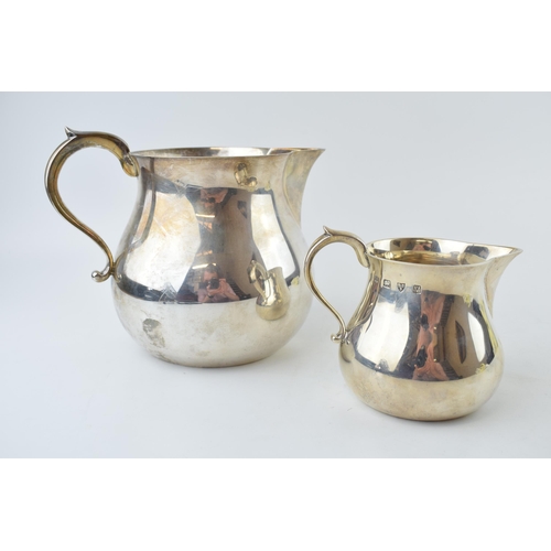 279 - A near graduated pair of silver bulbous jugs, the larger being London 1964, Edward Barnard & Sons, 2... 