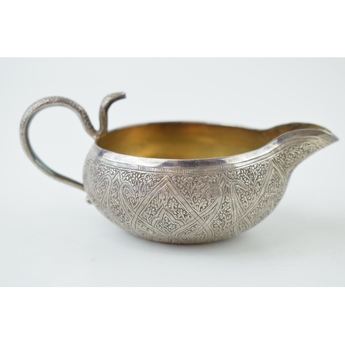 325 - A white metal (tests as sterling silver) ornate pouring jug, heavily engraved decoration, with serpe... 