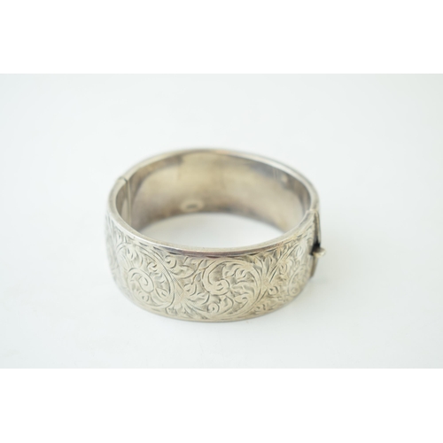 341 - Vintage silver bangle with hand chased repeated design. Weight 35.1 grams.