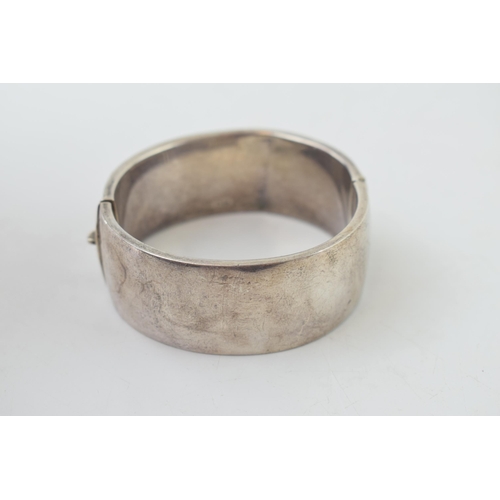 341 - Vintage silver bangle with hand chased repeated design. Weight 35.1 grams.