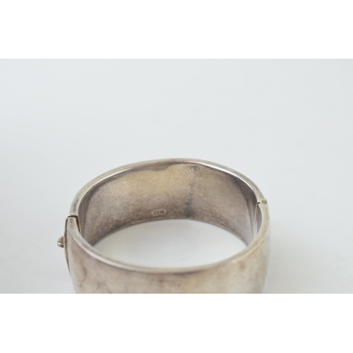 341 - Vintage silver bangle with hand chased repeated design. Weight 35.1 grams.