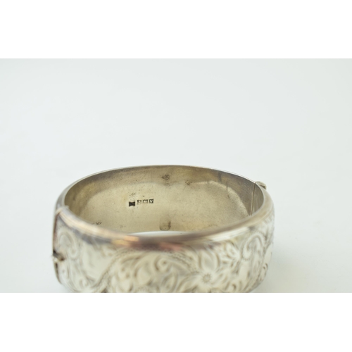 342 - Vintage silver bangle with hand chased repeated design. Weight 40 grams.