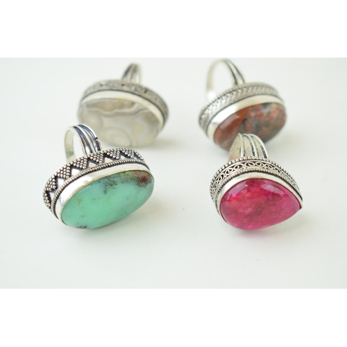 343 - Four large silver dress rings set with semi-precious stones. Gross weight 63 grams.