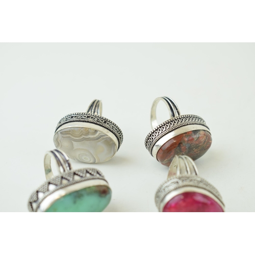 343 - Four large silver dress rings set with semi-precious stones. Gross weight 63 grams.