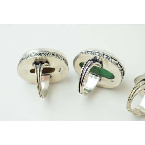 343 - Four large silver dress rings set with semi-precious stones. Gross weight 63 grams.