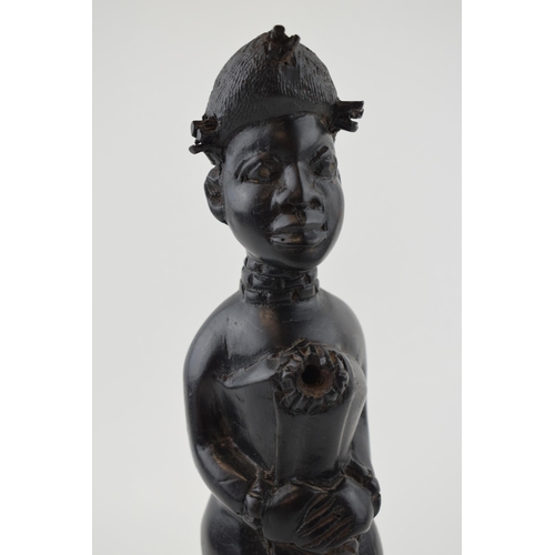 84 - African tribal figure of a lady with hands clasped over waste. Height 26cm.