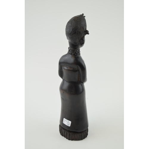 84 - African tribal figure of a lady with hands clasped over waste. Height 26cm.