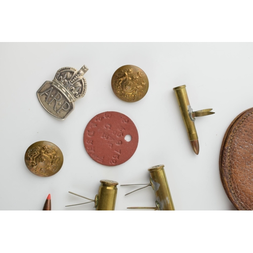 27 - A collection of military items to include A.R.P silver badge, Leather WWi pocket watch case and othe... 